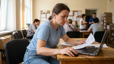 Жінка заповнює документи на ноутбуці у центрі гуманітарної підтримки