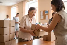 Літня жінка отримує коробку з гігієнічними засобами у гуманітарному центрі