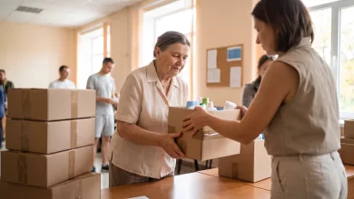 Літня жінка отримує коробку з гігієнічними засобами у гуманітарному центрі